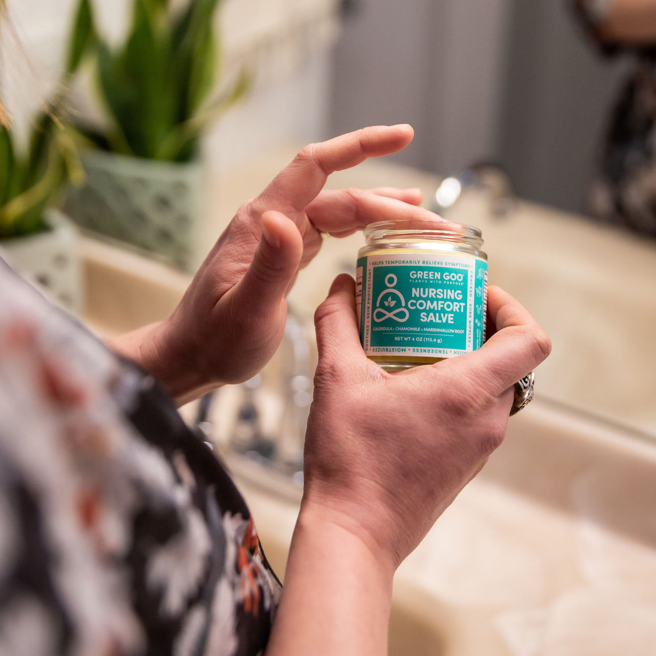 Nursing Salve Jar with person applying to fingers