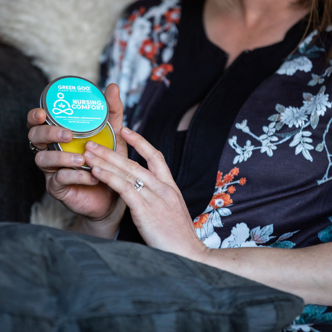 Nursing Salve Tin Open with person applying to fingers